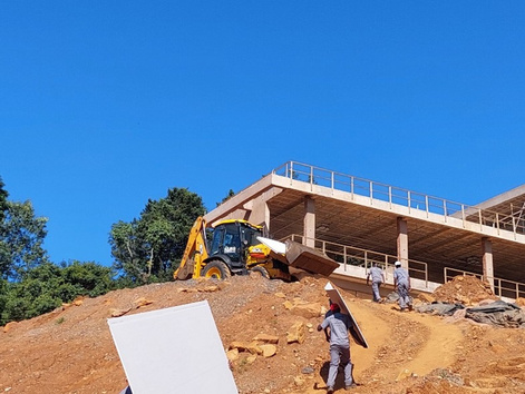 Backhoe loader working beside a new concrete structure